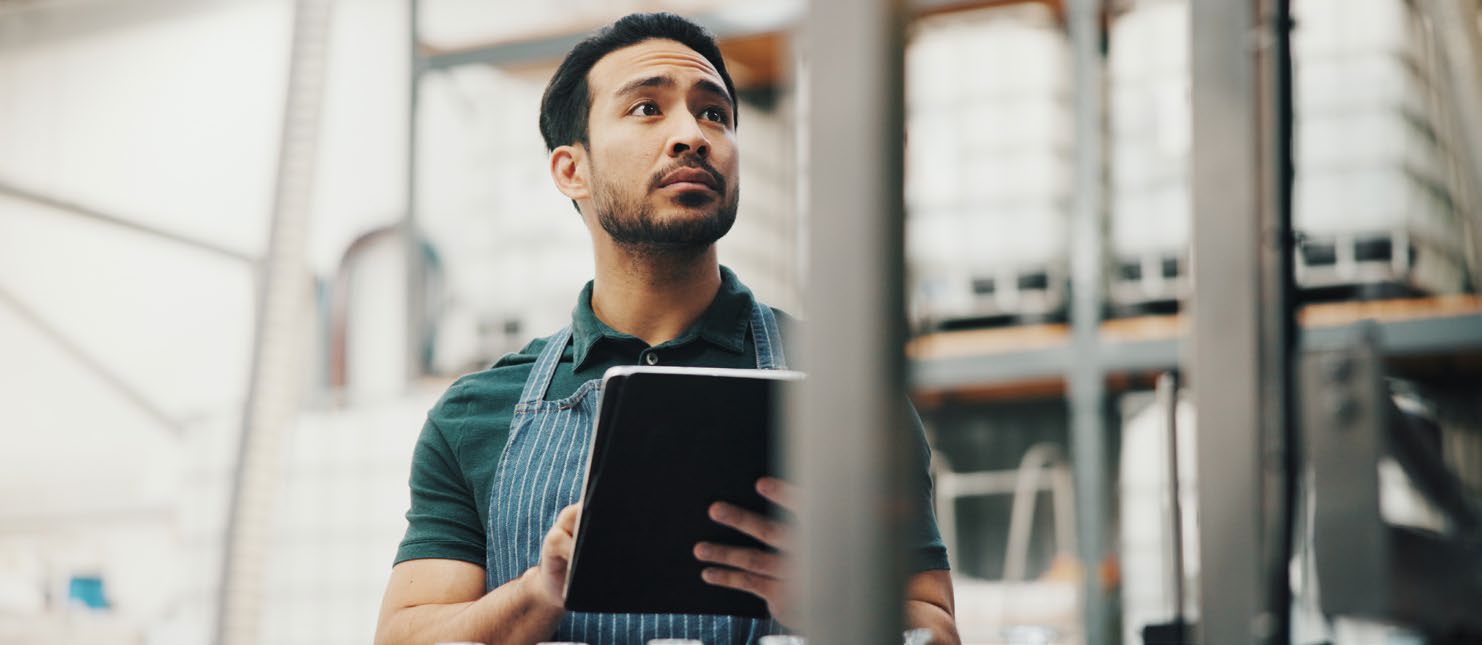 Man with iPad looking at inventory in warehouse